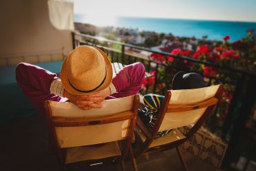 Dad And Son Relax On Balcony Terrace With Sea View