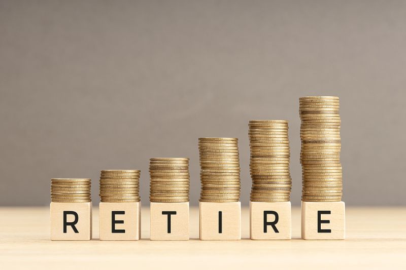 Retire Word In Wooden Blocks With Coins Stacked In Increasing St